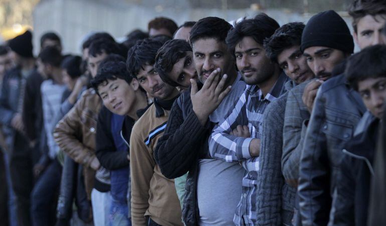 Varios refugiados hacen cola para recibir alimentos en el centro de recepción de Moria en la isla de Lesbos, Grecia