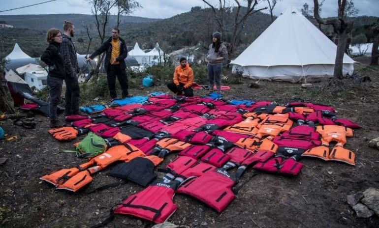 Chalecos salvavidas atados entre sí formando un colchón gigante para los refugiados de Lesbos