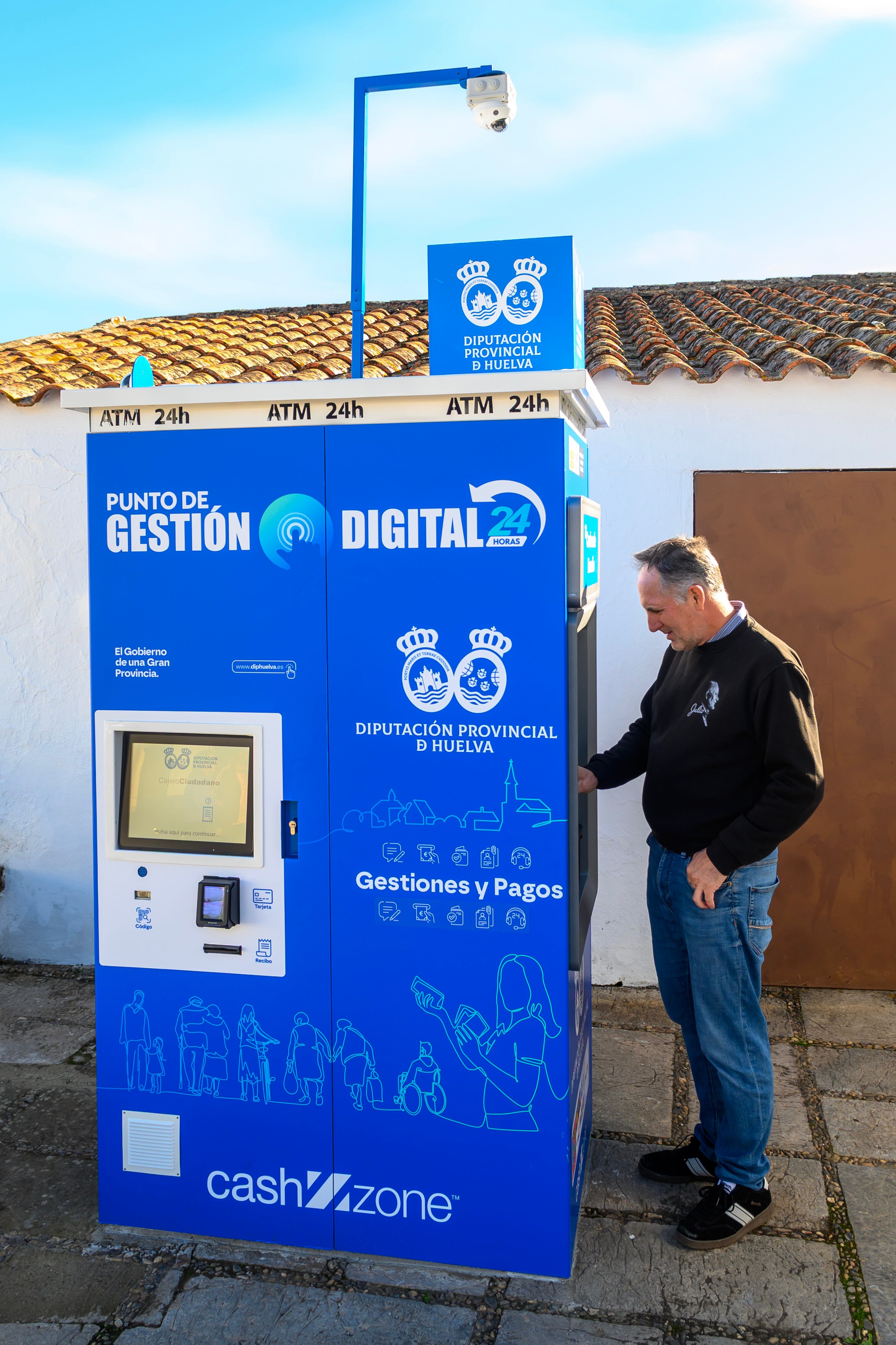 GRAFAND1711. CUMBRES DE ENMEDIO (HUELVA), 10/11/2025.- Uno de los 61 habitantes de Cumbres de Enmedio, el municipio menos poblado de Huelva y el segundo de Andalucía, utiliza el cajero automático con el que cuenta el municipio desde este lunes y que convertirá en cotidianas tareas como sacar dinero o pagar recibos, avanzando en la igualdad financiera. EFE/Raúl Caro