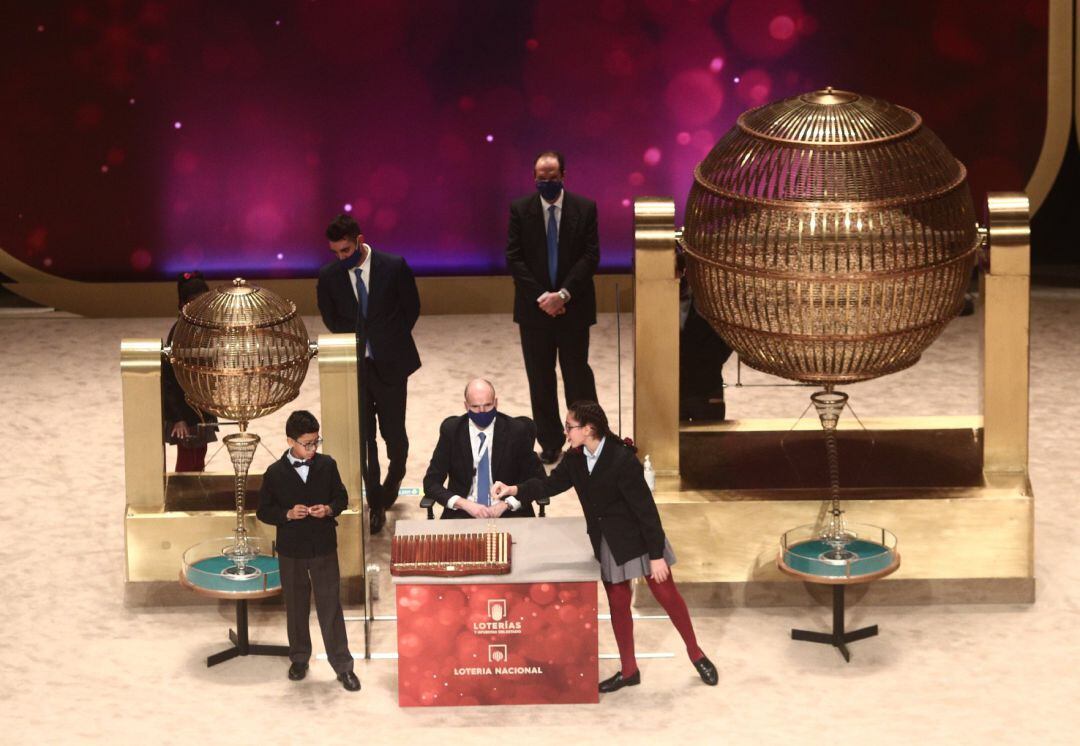 Dos de los niños de la residencia de San Ildefonso Salvador Constantin Roaan y Noura Akrouh cantan alguno de los premios durante la celebración del Sorteo Extraordinario de la Lotería de Navidad 2020 en el Teatro Real de Madrid