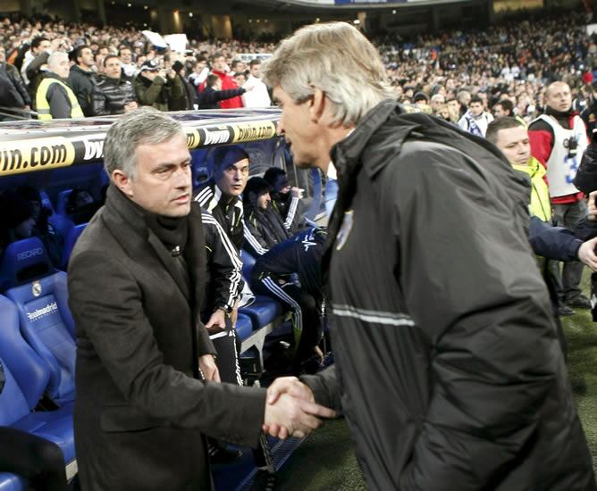 El entrenador chileno del Málaga, Manuel Pellegrini (d), saluda al técnico portugués del Real Madrid José Mourinho (i), momentos antes del inicio del partido, correspondiente a la vigesimosexta jornada de Liga de Primera División, que ambos equipos disput