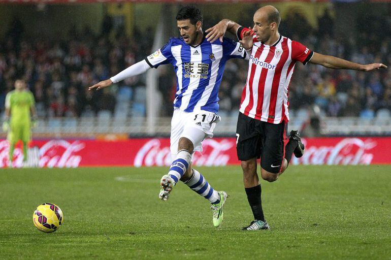 GRA258. SAN SEBASTIÁN, 14/12/2014.- El delantero mexicano de la Real Sociedad, Carlos Vela (i), lucha un balón con Mikel Rico, del Athletic Club,, durante el partido de la decimoquinta jornada de Liga de Primera División que se juega hoy en el estadio de 