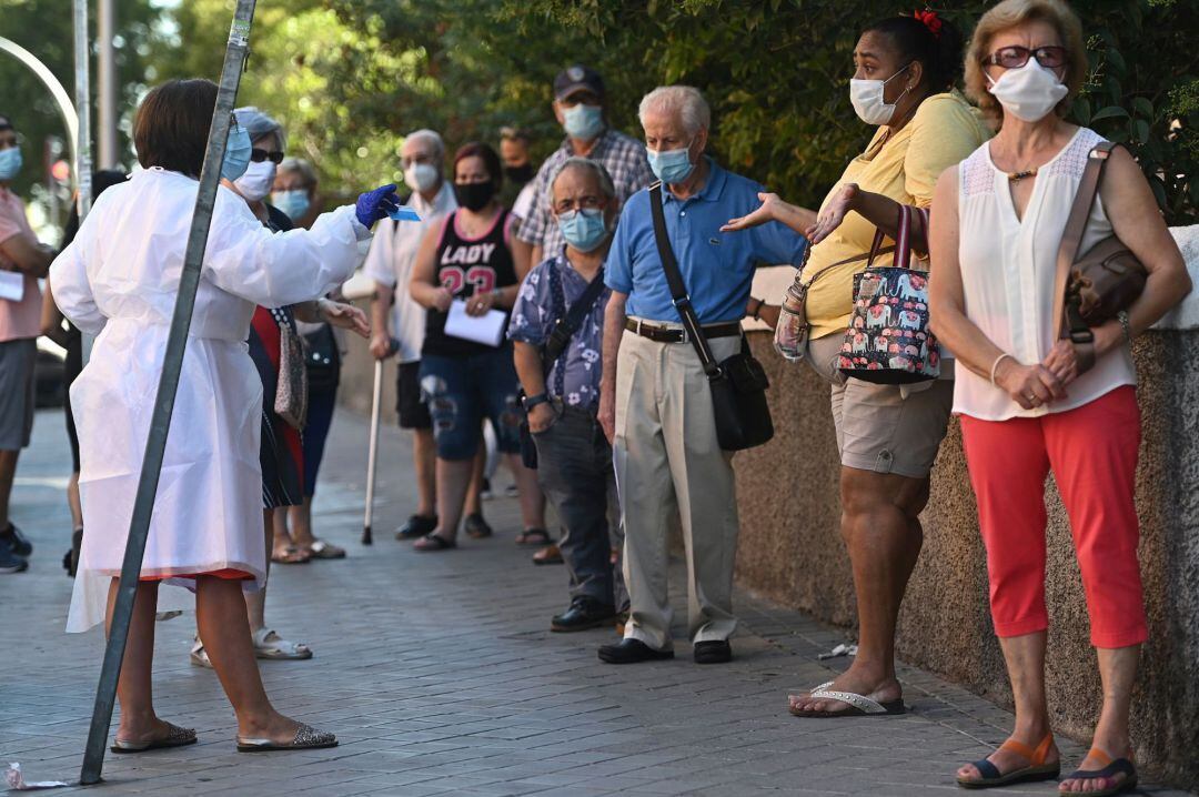 Varias personas esperan su turno para las pruebas aleatorias de PCR en un centro de salud en el distrito de Carabanchel en Madrid