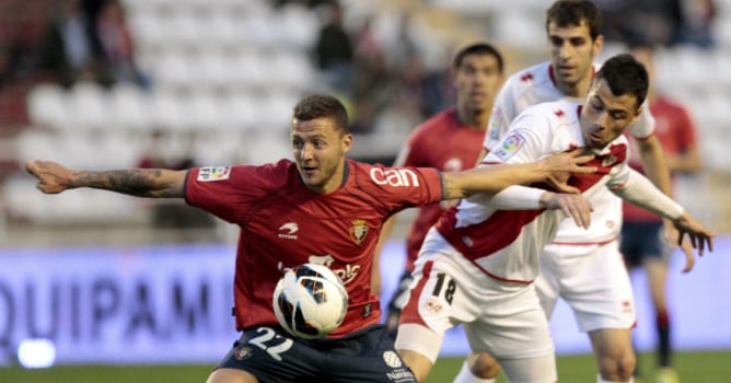 El centrocampista del Osasuna David Timor defiende el balón ante el acoso del centrocampista del Rayo Vallecano Javi Fuego, durante el partido de la vigésimo tercera jornada de la Liga de Primera División que se disputó en el Campo de Fútbol de Vallecas