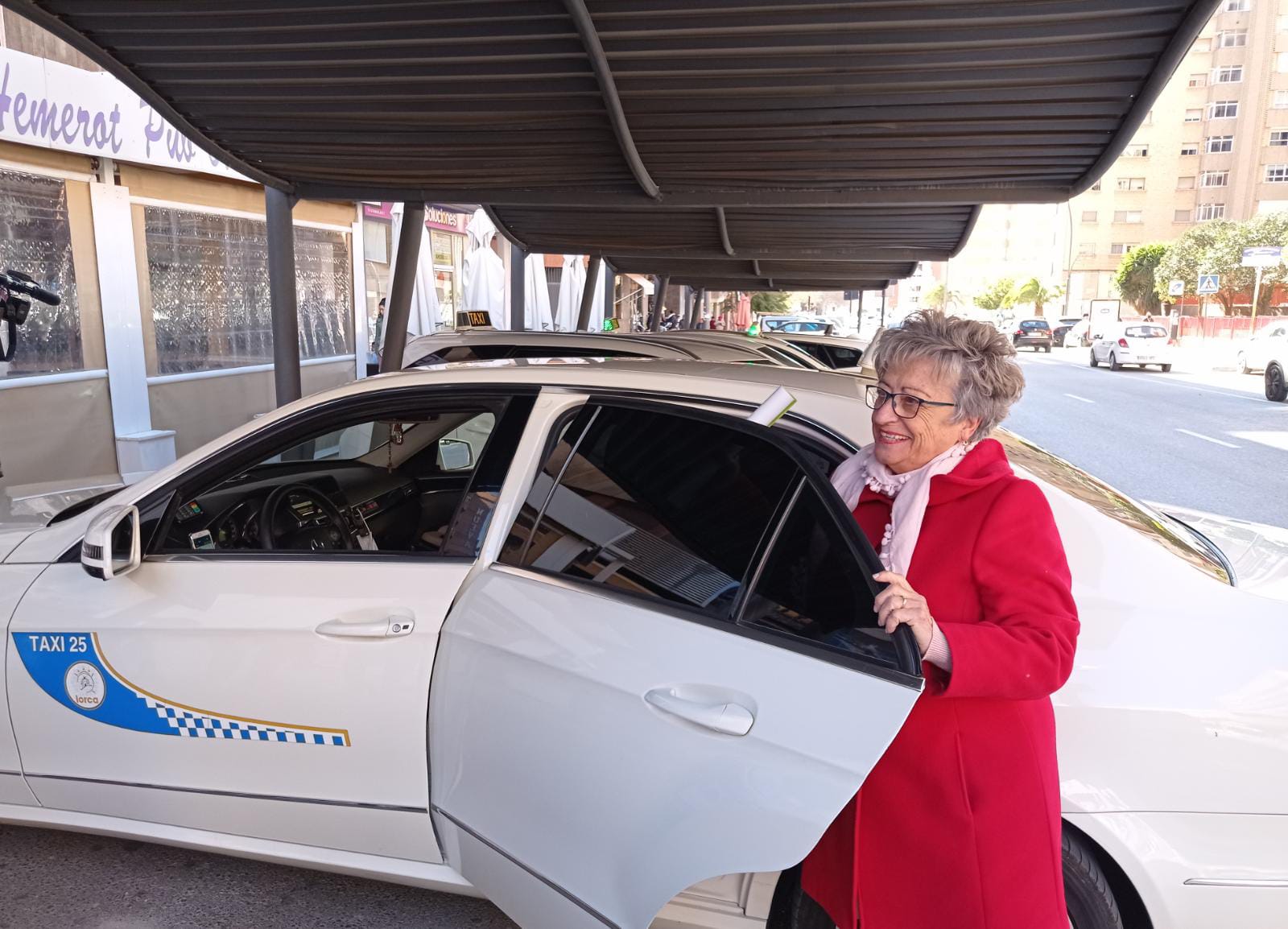 Bienvenida Fernández, presidenta de la Federación Espantaría se sube al taxi rural en la parada del Óvalo de Lorca