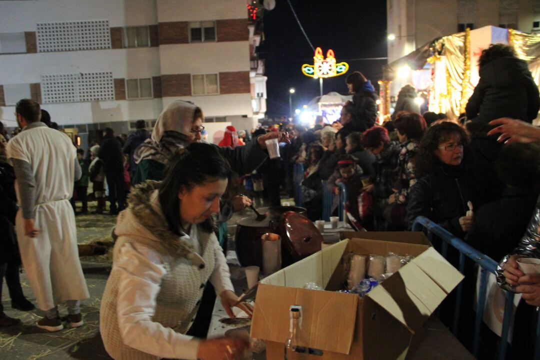 Varias personas reparten caldo y chocolate en un belen viviente en las Navidades de 2018