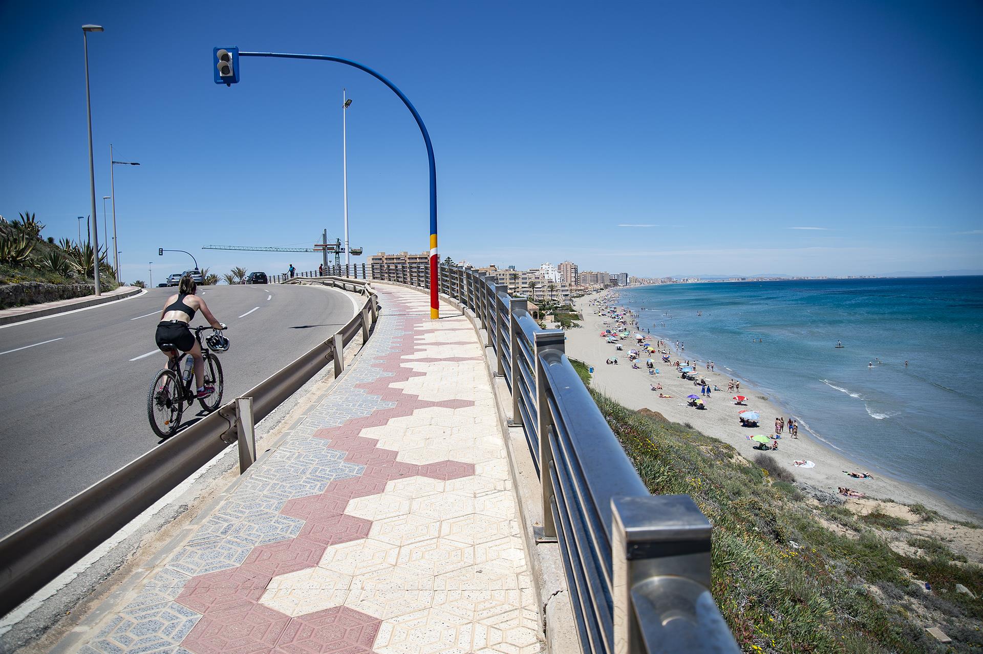 Una ciclista circula cerca de la Playa Galúa, en la Manga del Mar Menor