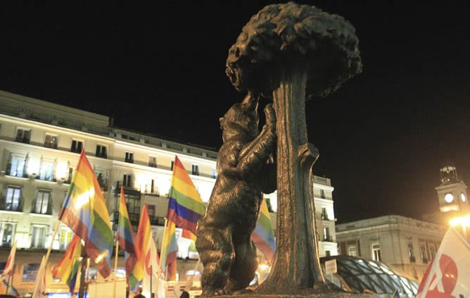 Banderas arcoíris junto a la escultura del Oso y el Madroño, en la Puerta del Sol en Madrid, donde colectivos de gays y lesbianas celebran la decisión adoptada por el Tribunal Constitucional español de avalar el matrimonio homosexual