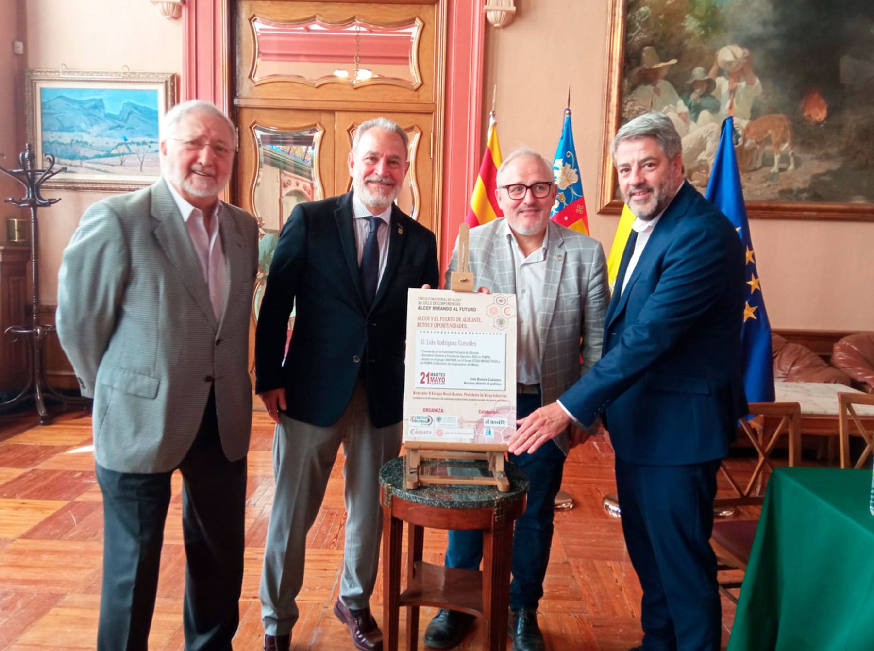 Enrique Masià, Indalecio Carbonell, Pau Bernabeu y Pablo de Gracia, junto al cartel de la próxima conferencia del ciclo 'Alcoy, mirando al futuro'