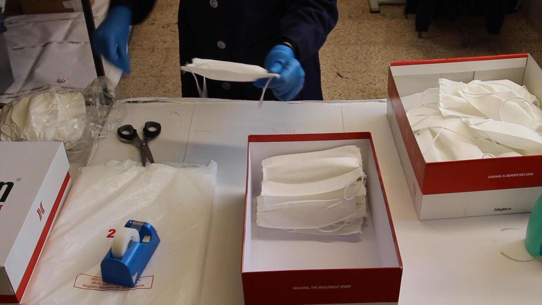 Un operario de Zapatos Callaghan manipulando mascarillas. 