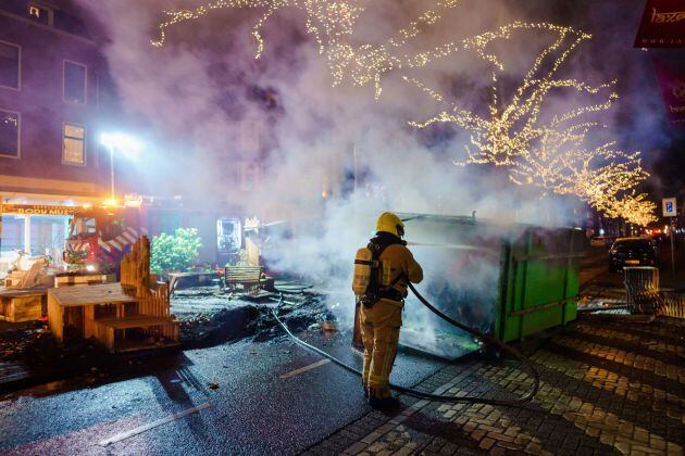 Un bombero extingue el fuego provocado por las protestas en Groene Hilledijk (Rotterdam).