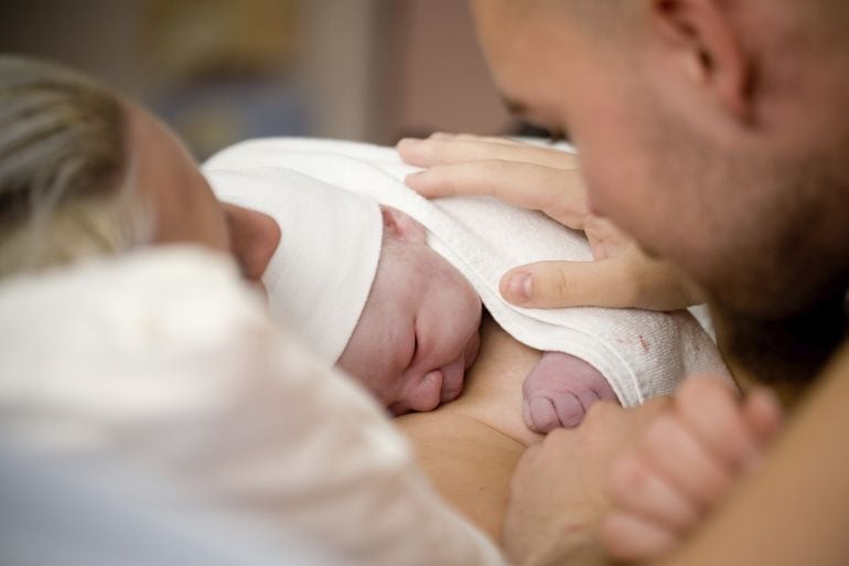 Imagen recurso de un bebé recién nacido con sus padres.