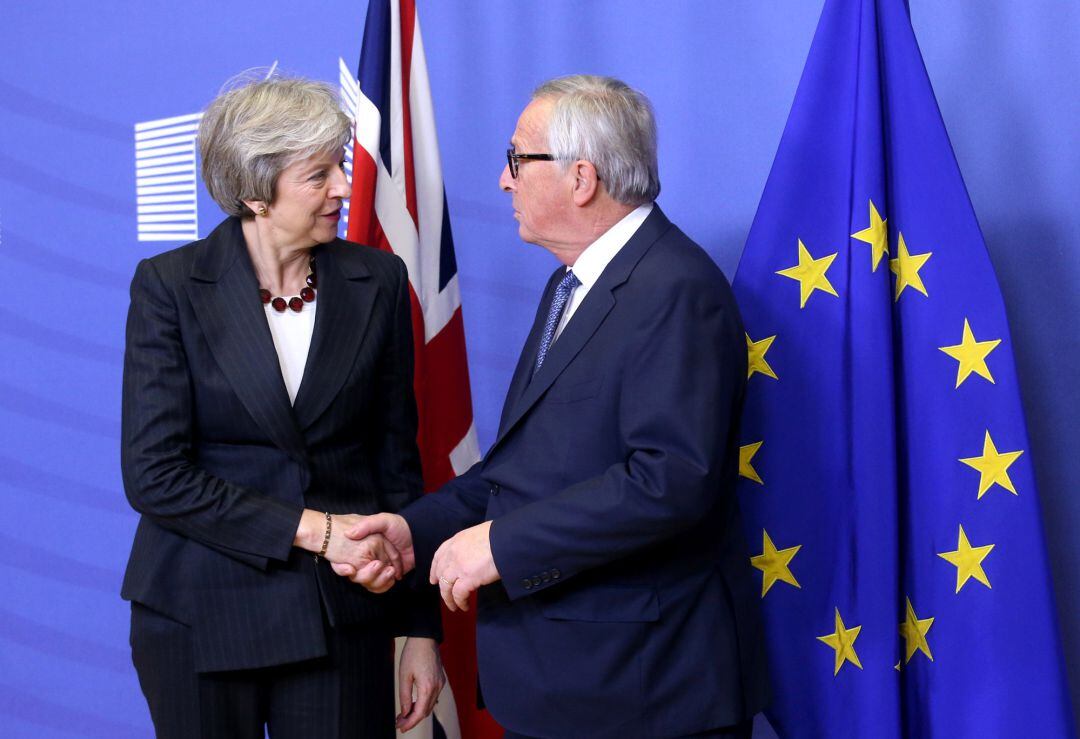 Theresa May y Jean-Claude Juncker se saludan antes de su reunión