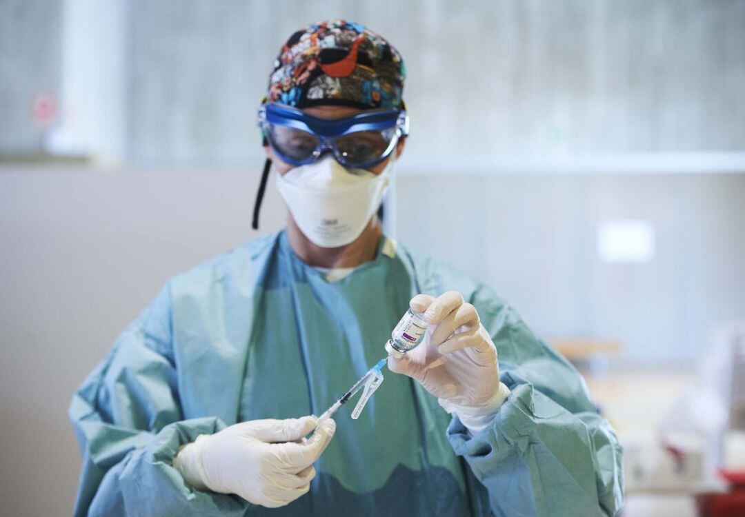 Una profesional sanitaria sostiene un vial con la vacuna de AstraZeneca