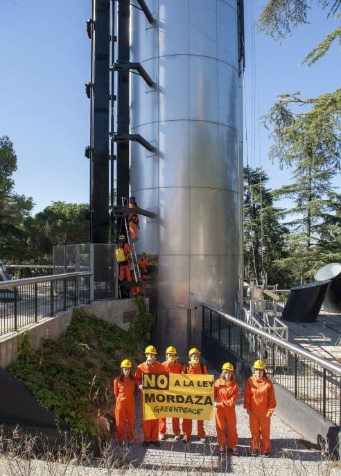 Fotografía facilitada por Greenpeace de sus activistas que han comenzado a escalar el mirador del Faro de Moncloa en Madrid para mostrar su rechazo al proyecto de Ley de Seguridad Ciudadana