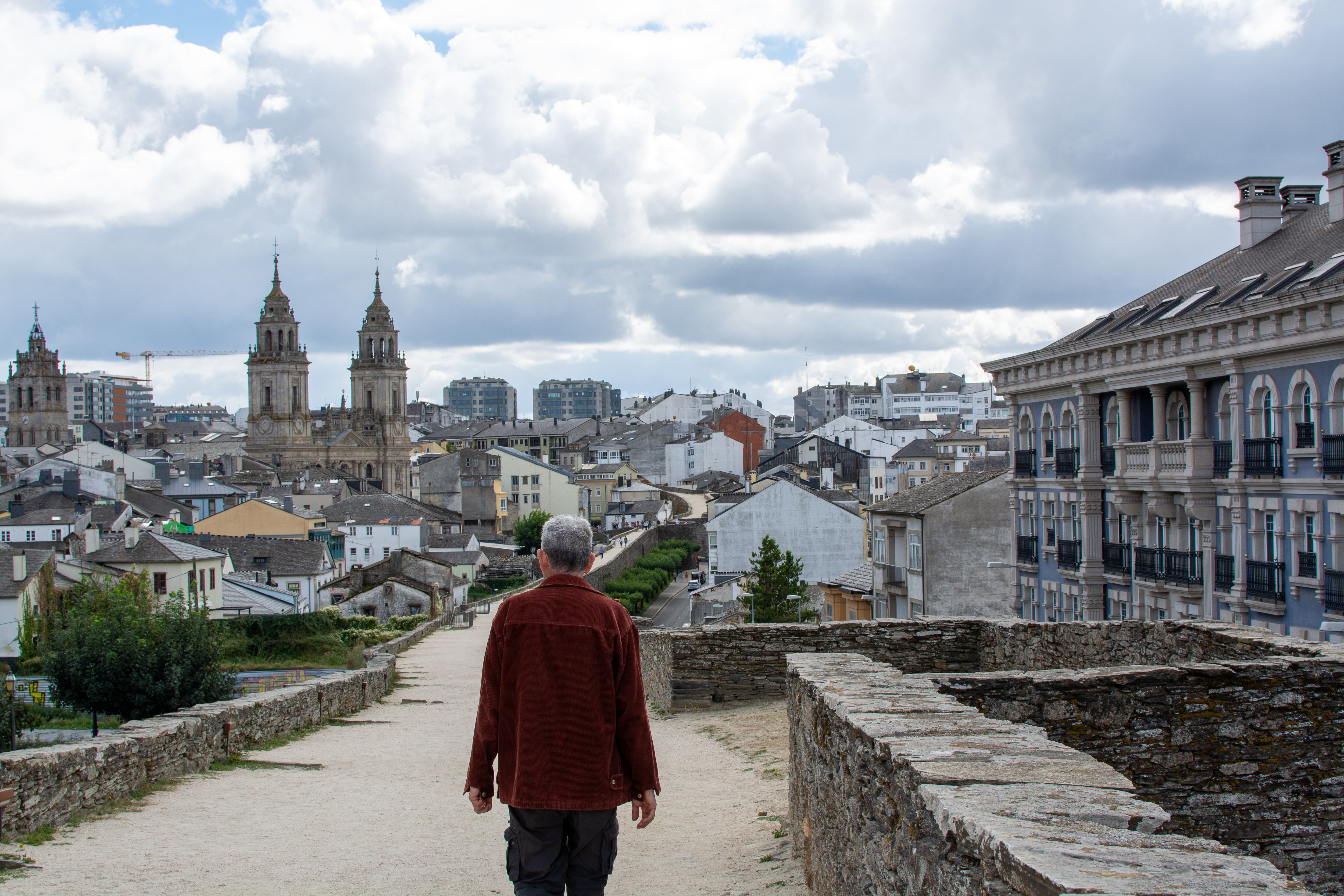 Un hombre camina por la Muralla de Lugo