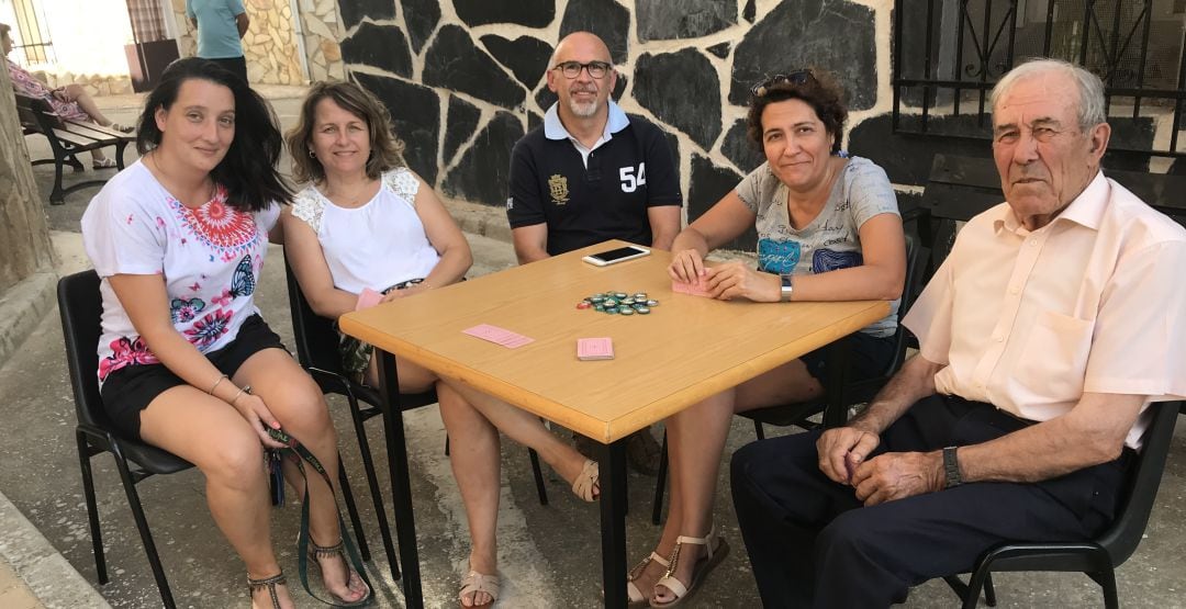 Un grupo de vecinos de Arrancacepas (Cuenca) juega a las cartas junto al centro social.