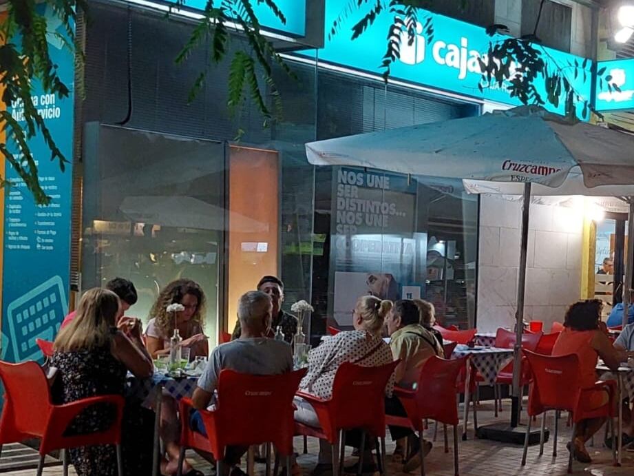 Terraza ocupante la entrada a una entidad bancaria en el barrio