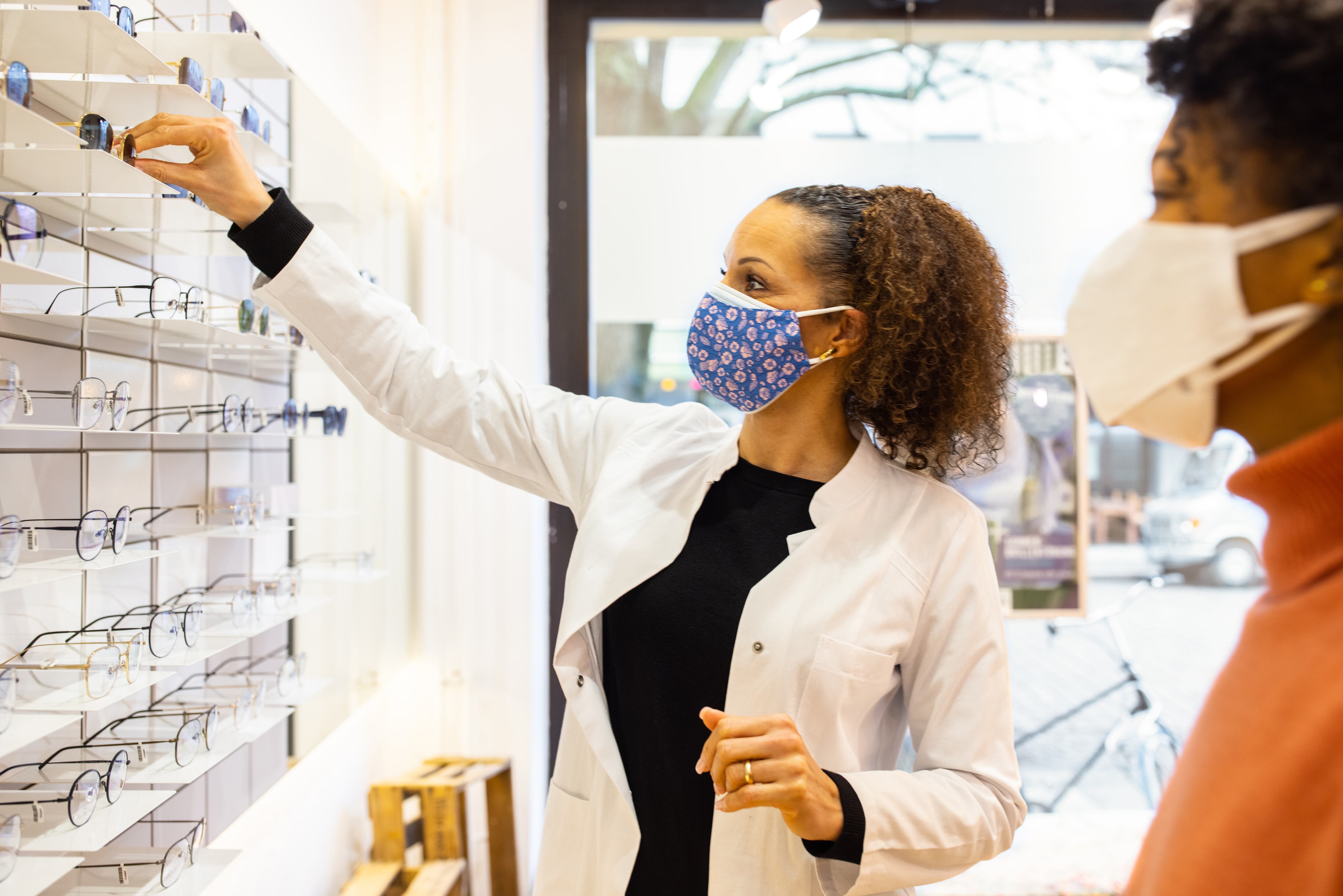 Una mujer atiende a un cliente en una tienda de óptica.