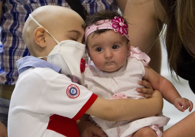 Antonio, el niño granadino de seis años que ha logrado superar una enfermedad hereditaria gracias a la transfusión de células del cordón umbilical de su hermana Estrella, a quien abraza, seleccionada genéticamente y totalmente compatible con él, tras ser dado de alta en el Hospital Virgen del Rocío de Sevilla.