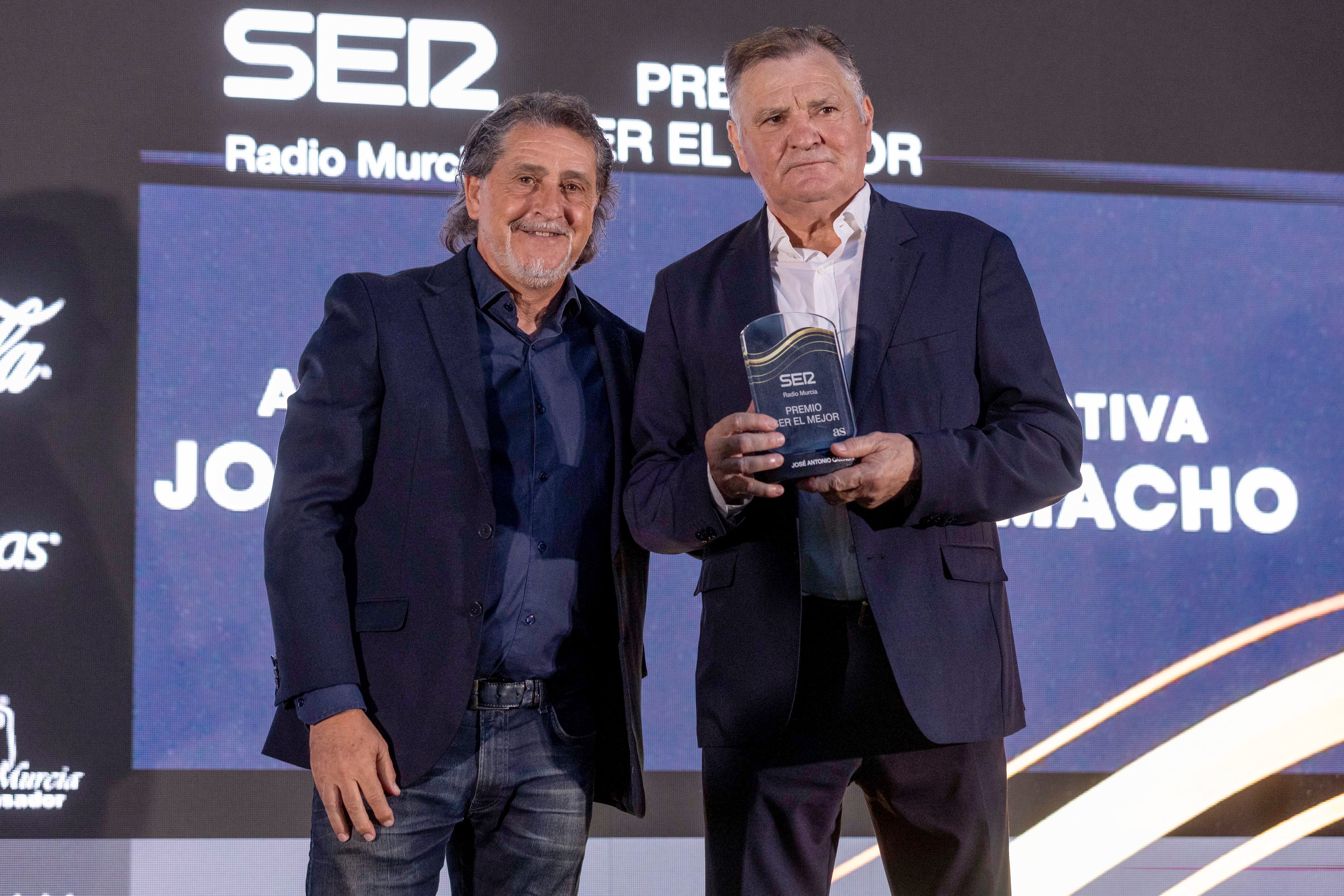 MURCIA, 16/06/2025.- El técnico de fútbol, José Antonio Camacho (d), acompañado por el exfutbolista, Raúl Ruiz, tras recibir el premio a su ´Trayectoria´ durante la entrega de los premios que otorga la Cadena Ser Murcia ´El Mejor 2025´, hoy lunes en Murcia. EFE/Marcial Guillén.