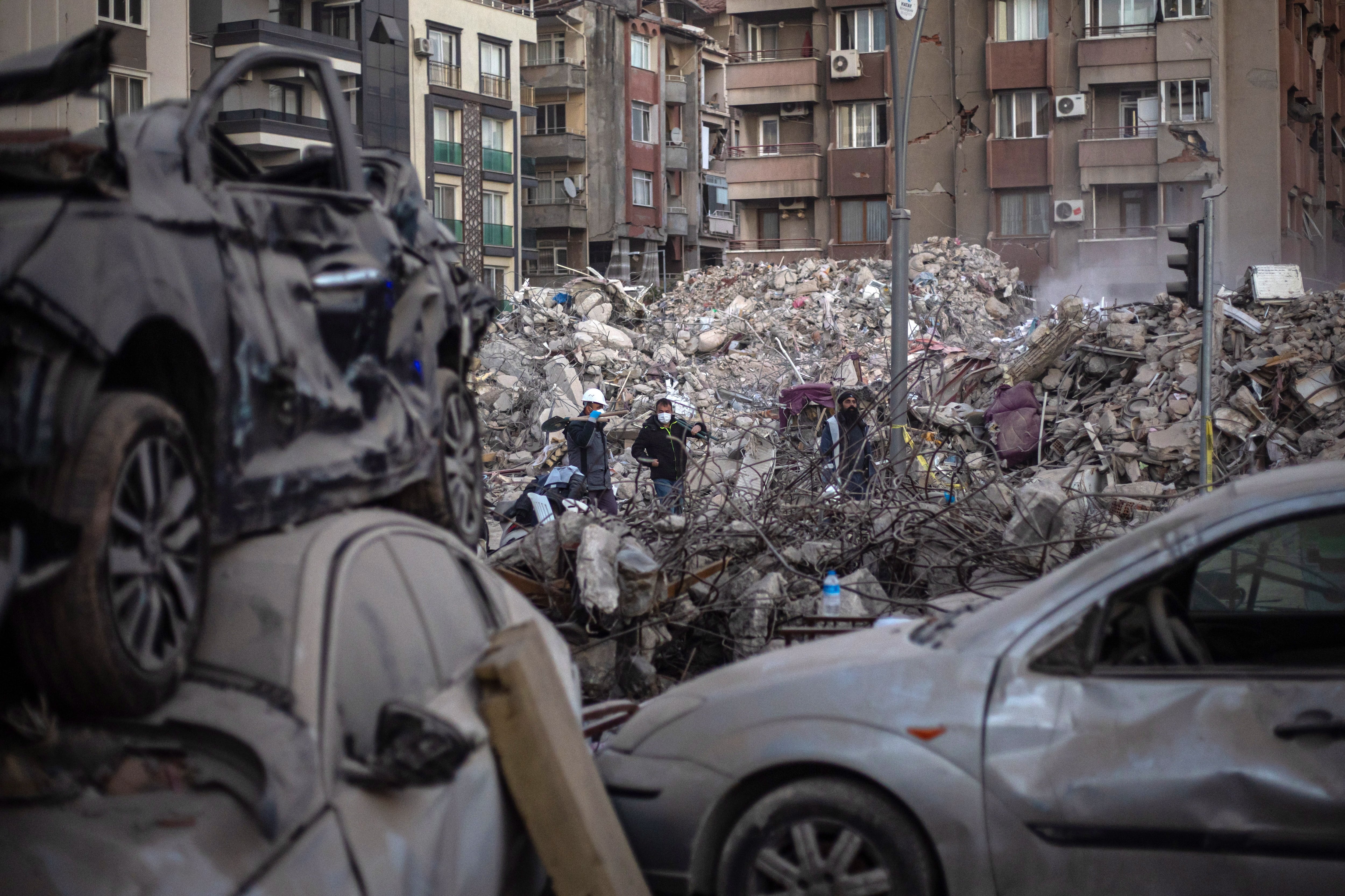 Hatay (antakya) (Turkey), 15/02/2023.- Workers walk between collapsed buildings after the powerful earthquake in Hatay, Turkey, 15 February 2023. More than 41,000 people have died and thousands more are injured after two major earthquakes struck southern Turkey and northern Syria on 06 February. Authorities fear the death toll will keep climbing as rescuers look for survivors across the region. (Terremoto/sismo, Siria, Turquía, Estados Unidos) EFE/EPA/MARTIN DIVISEK
