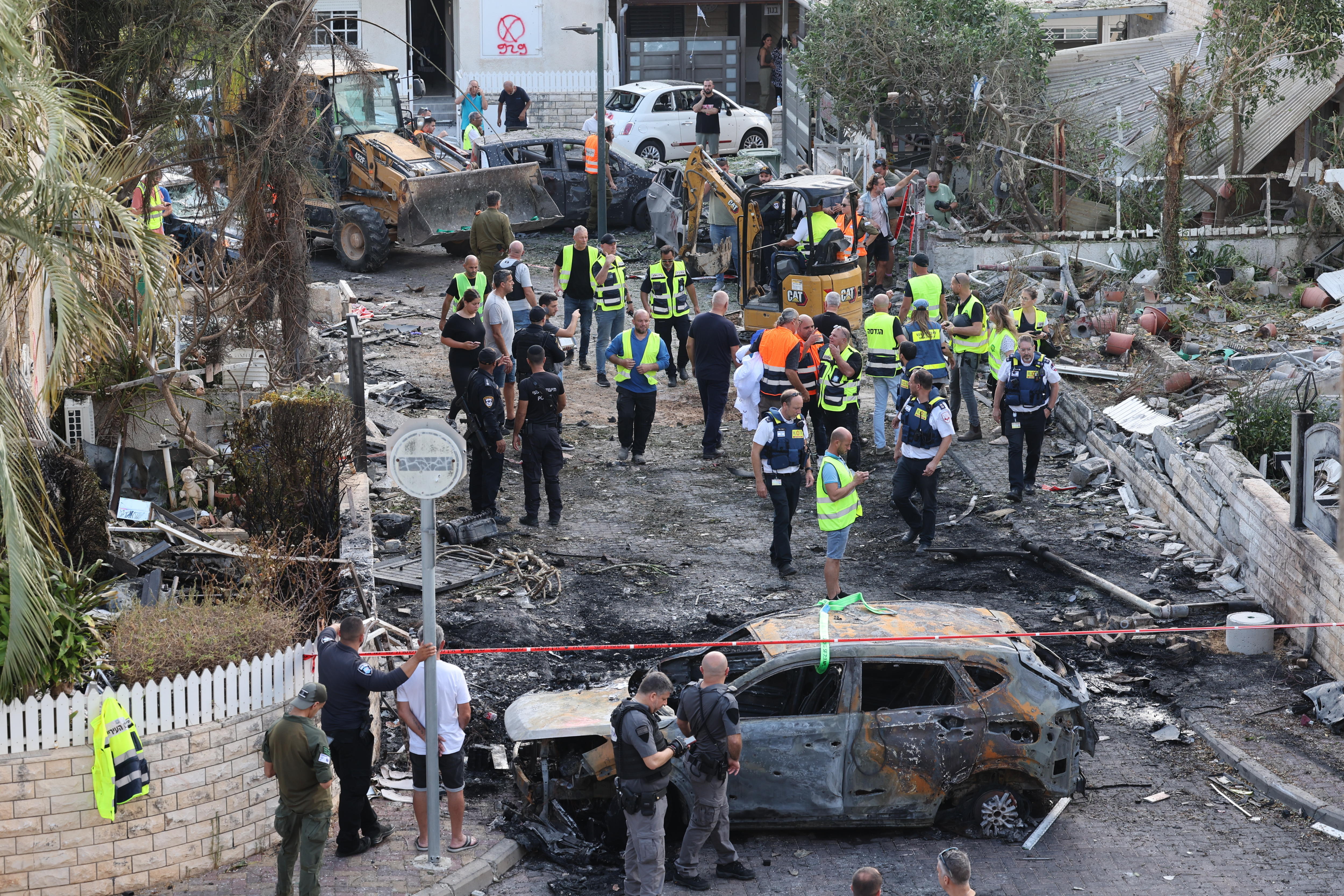 Los equipos de emergencia israelíes trabajan en el lugar donde cayó un ataque con misiles en un barrio residencial de Kiryat Bialik, en el norte de Israel