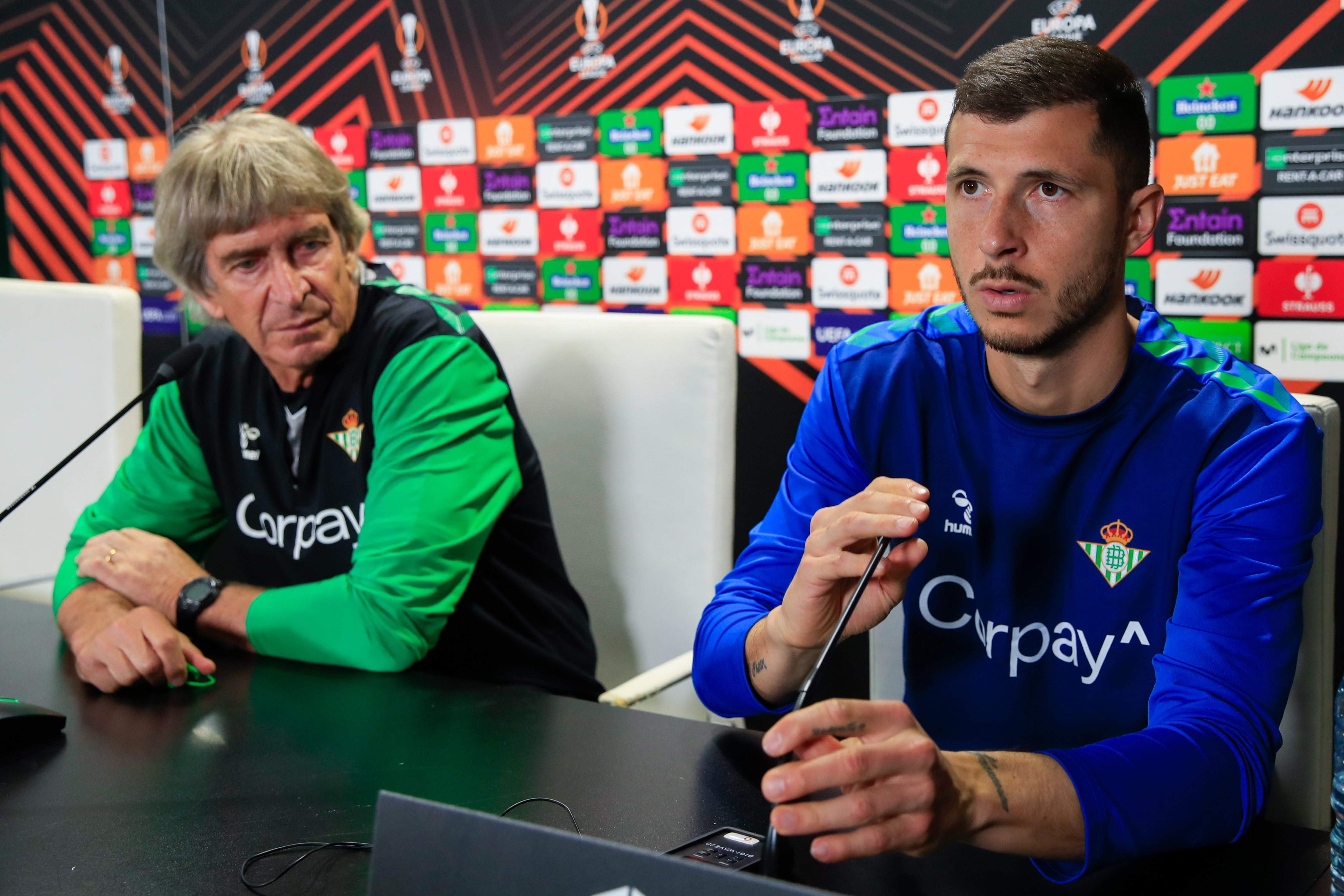 GRAFAND8832. SEVILLA, 15/03/2023.- El central argentino del Real Betis Guido Rodríguez, junto al entrenador, Manuel Pellegrini, durante la rueda de prensa tras el entrenamiento realizado este miércoles en el estadio Benito Villamarín, donde mañana jueves se enfrenta al Manchester United en el partido de vuelta de octavos de final de la Liga Europa en Sevilla. EFE/Julio Muñoz .
