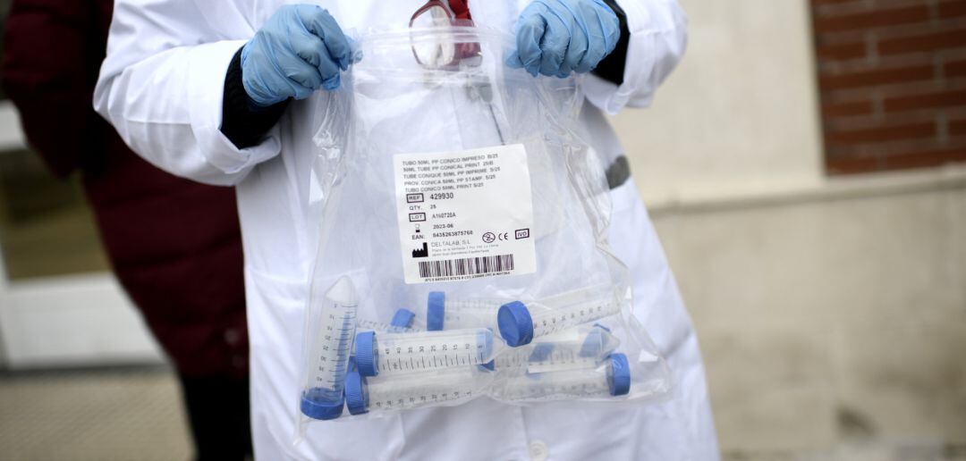 Un sanitario con tubos de ensayo durante la realización de tests de RT-PCR 