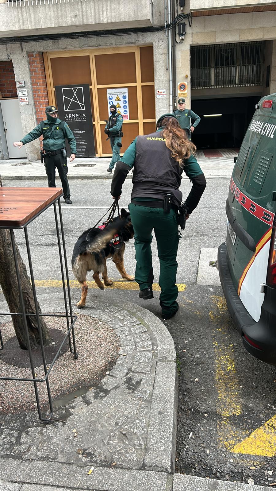 En la imagen una unidad canina se dispone a entrar en el garaje que están registrando