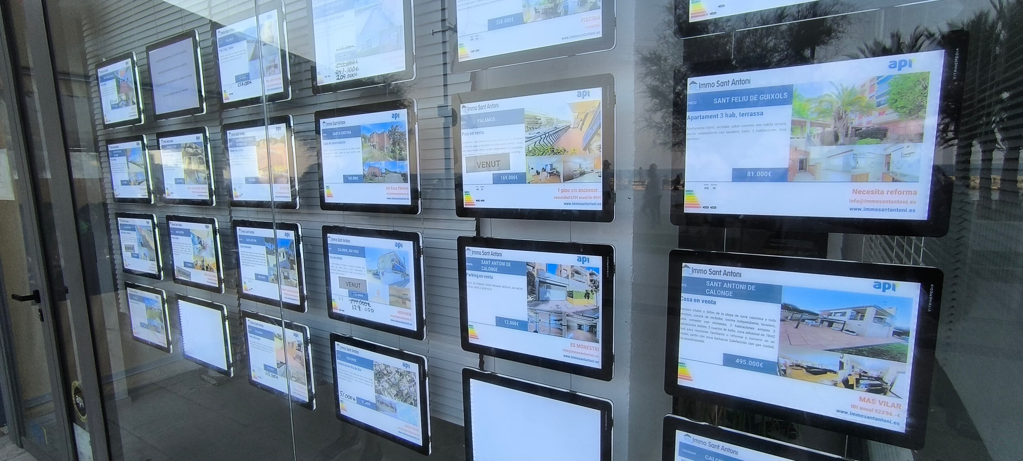 Oferta de pisos a la venta en el escaparate de una inmobiliaria