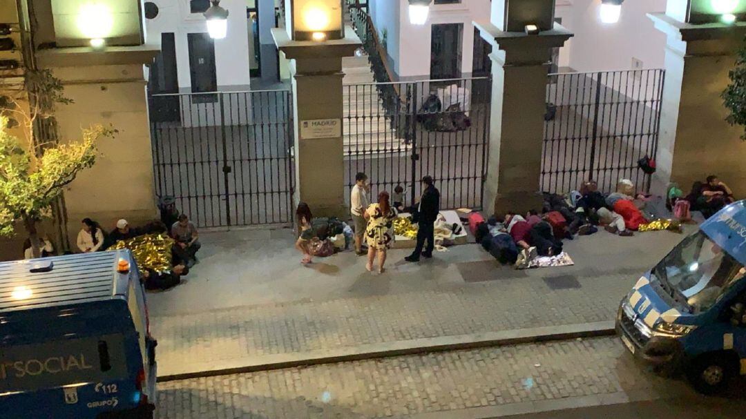 Varias familias pasan la noche frente al edificio del SAMUR Social de la calle Carrera de San Francisco.