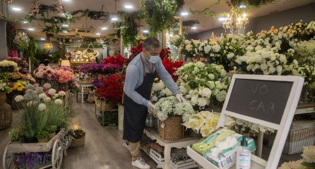 El empleado de una tienda de decoración protegido con mascarilla y guantes.