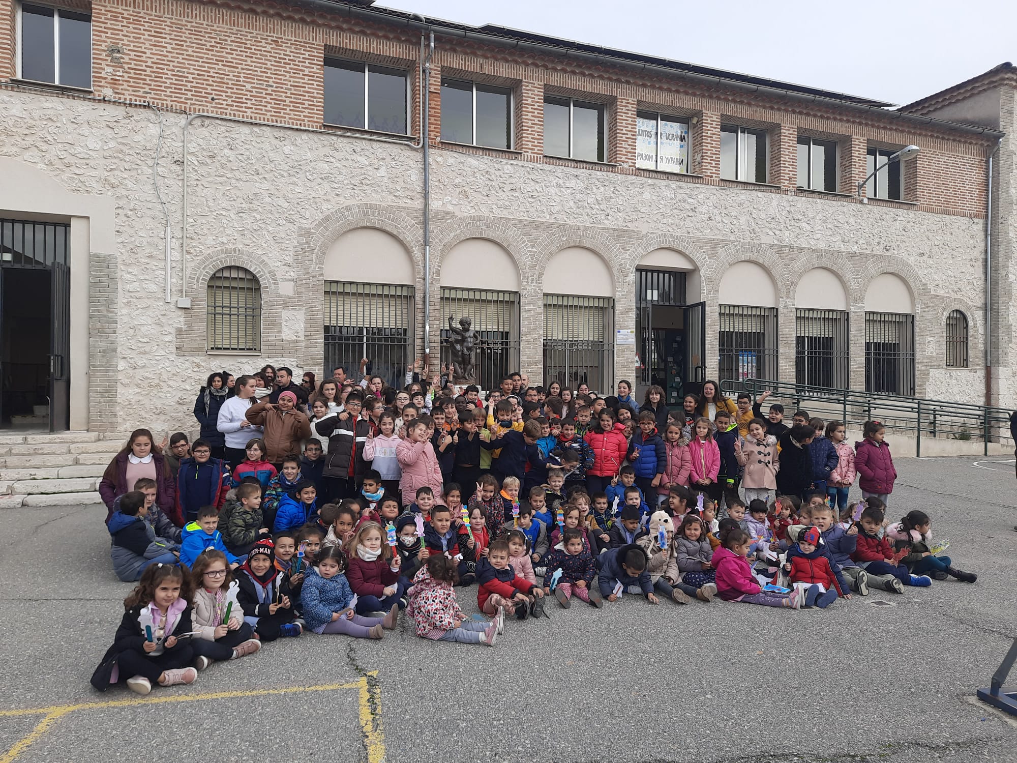 La comunidad educativa del colegio La Villa de Cuéllar junto con los concejales y el alcalde entorno a la estatua de los niños