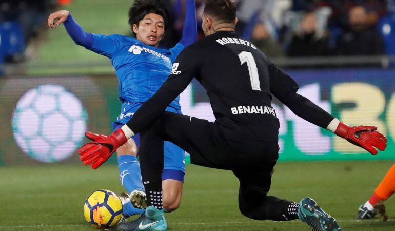 El centrocampista japonés del Getafe Gaku Shibasaki (i) trata de superar la salida del portero Roberto Jiménez, del Málaga, durante el último partido de Liga en Primera División disputado en el Coliseum Alfonso Pérez, en Getafe.
