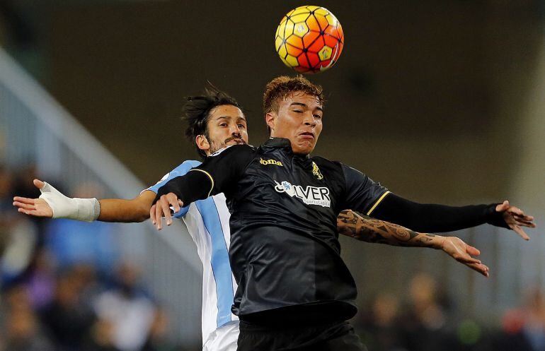 El delantero venezolano del Granada Peñaranda  salta por el balón ante el defensa argentino del Málaga Angeleri