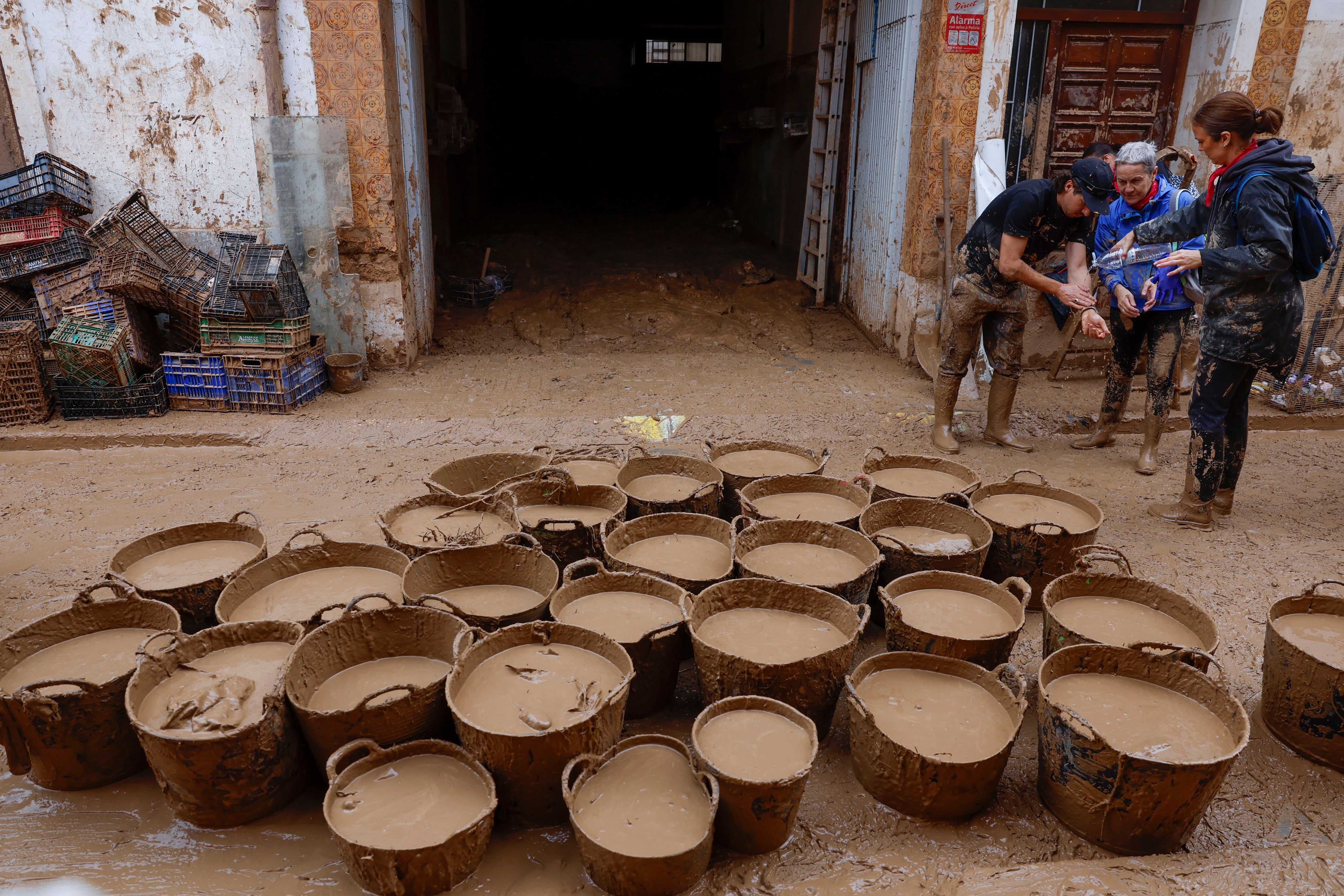 PAIPORTA (VALENCIA), 12/11/2024.- Cubos llenos de lodo en Paiporta, este martes. La dana que dejó en Valencia más de dos centenares de muertos y decenas de desaparecidos, ha cambiado la vida de miles de personas y condicionado la economía, el transporte y la educación de la provincia; dos semanas después prosigue el goteo de mejoras en infraestructuras y servicios básicos y, en paralelo, la polémica política por la gestión de la catástrofe. EFE/Jorge Zapata
