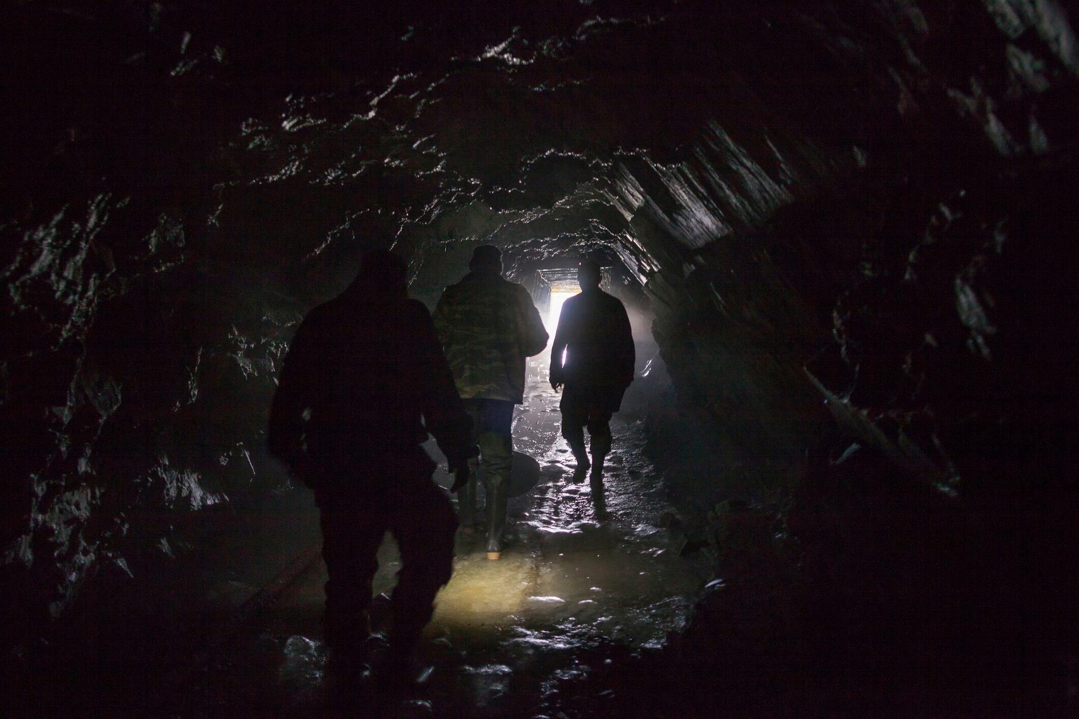 Men walking in dark cave