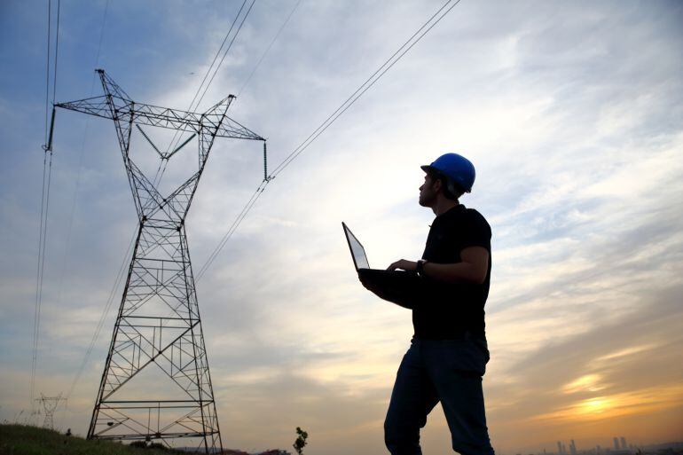 Un ingeniero comprueba una torre de electricidad