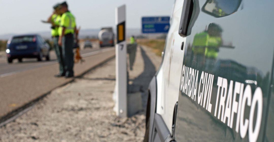 Una pareja de la Guardia Civil vigila el tráfico en una carretera.