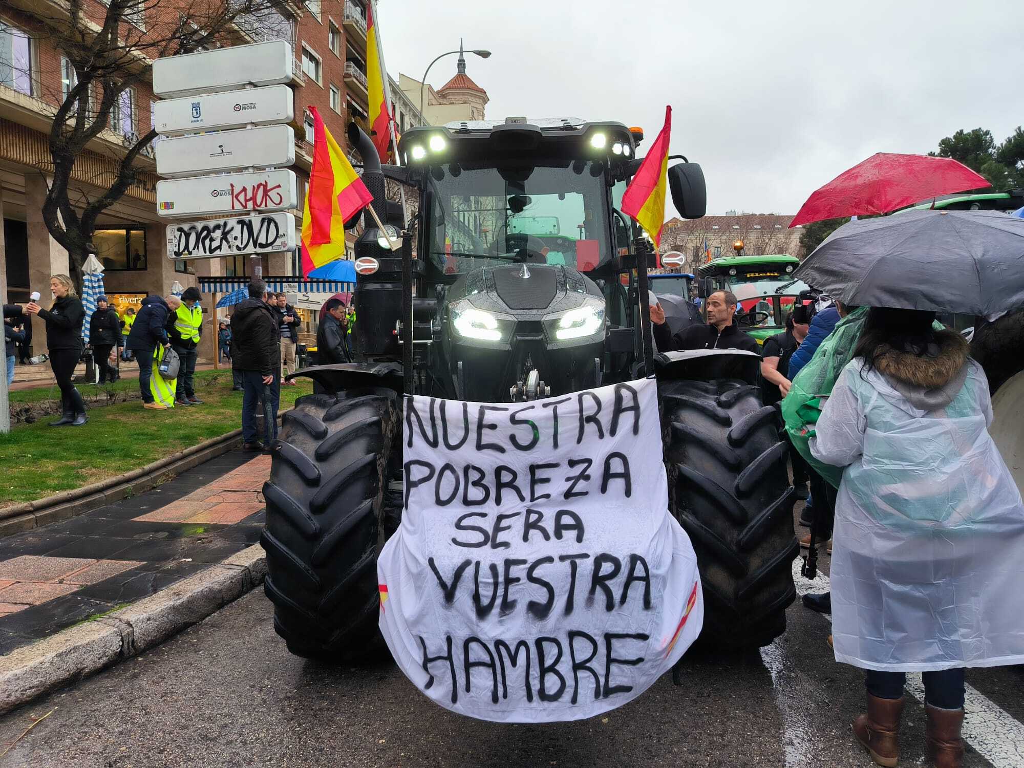 'Nuestra pobreza será vuestra hambre', reza una de las pancartas sobre uno de los tractores que se concentran este miércoles en Madrid