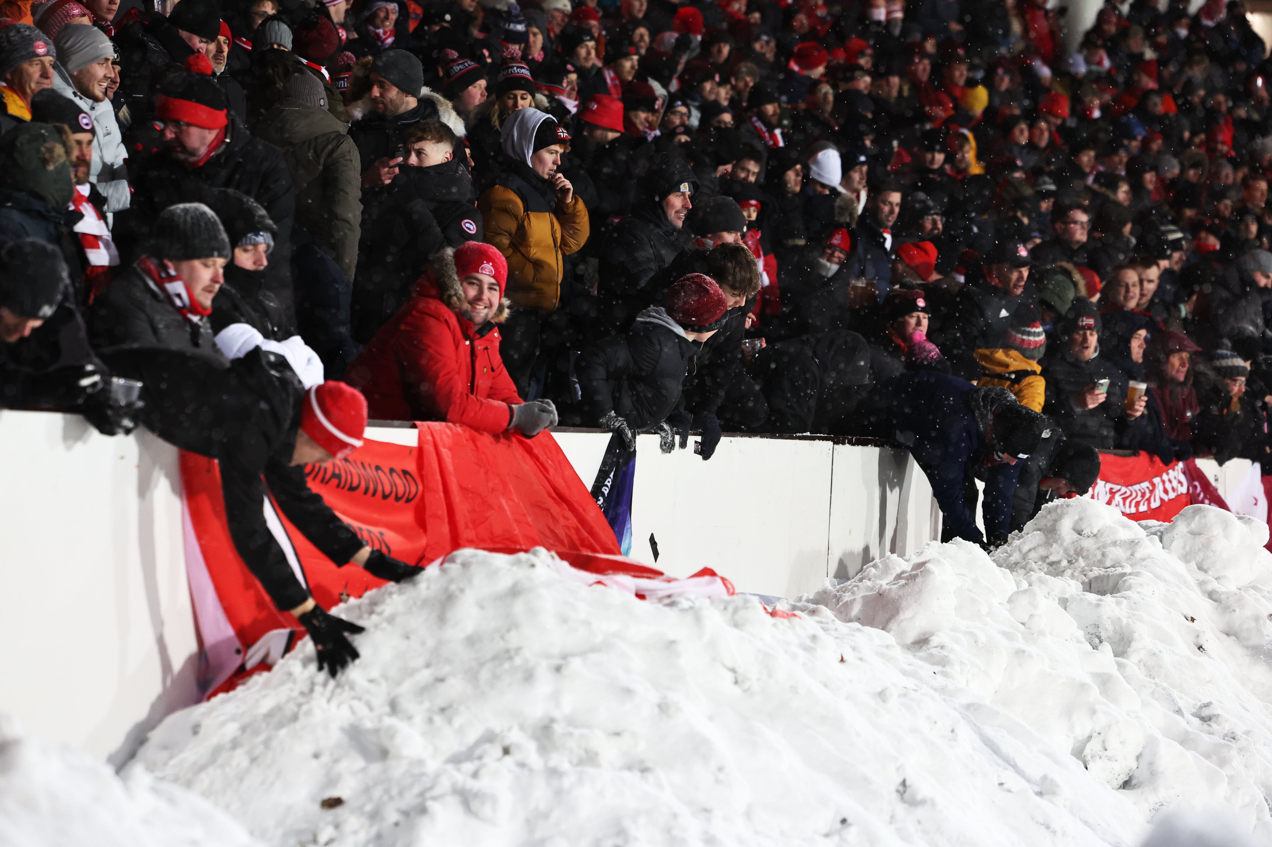 Aficionados del Aberdeen lanzan bolas de nieve al guardameta del HJK Helsinki durante un encuentro de la UEFA Europa Conference League.