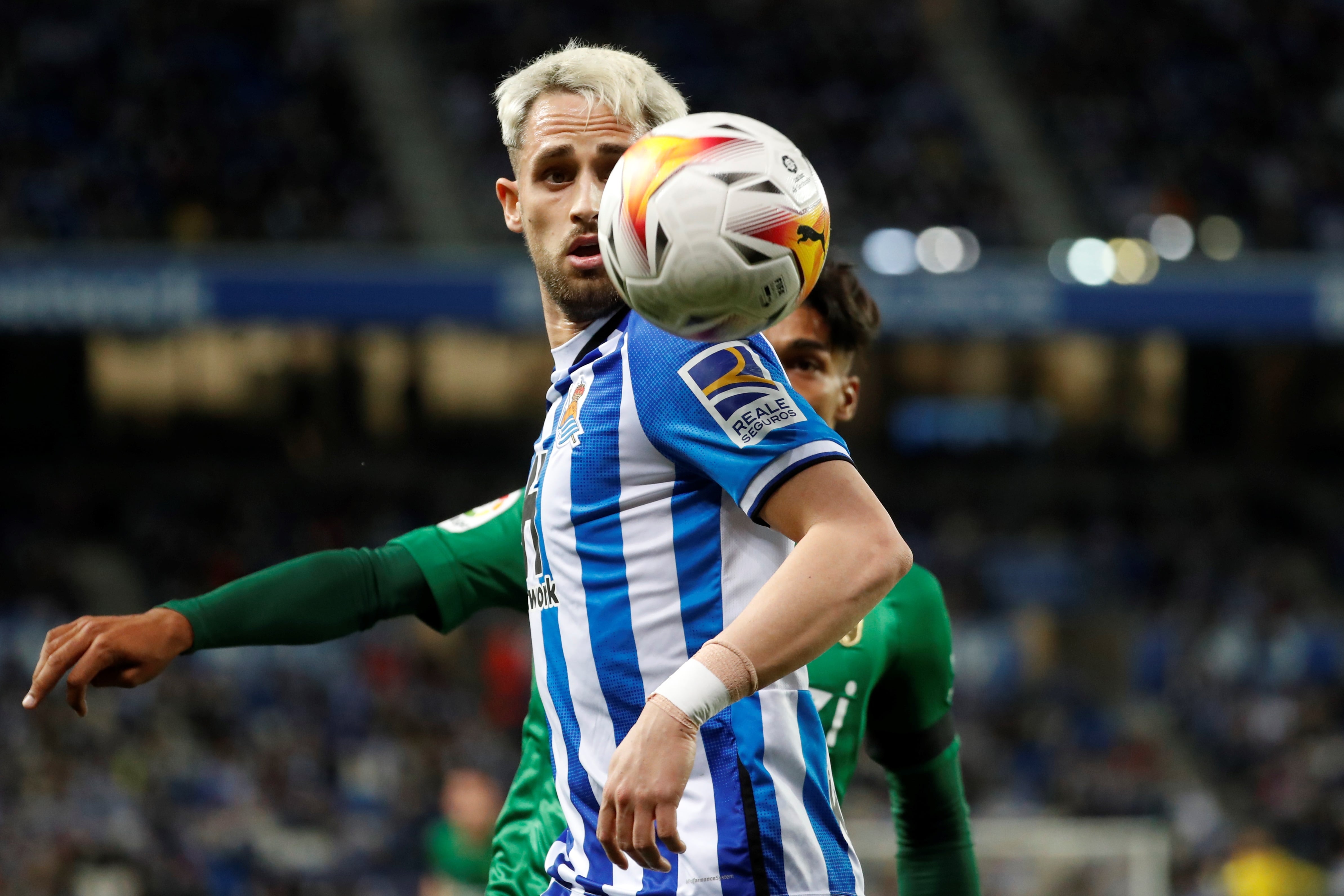 GRAF7526. SAN SEBASTIÁN, 13/02/2022.- El centrocampista belga de la Real Sociedad Adnan Januzaj (delante) intenta controlar el balón junto al uruguayo Douglas Arezo, del Granada CF, durante el partido de la jornada 24 de Liga en Primera División que se disputa hoy domingo en el Reale Arena, en San Sebastián. EFE/Juan Herrero
