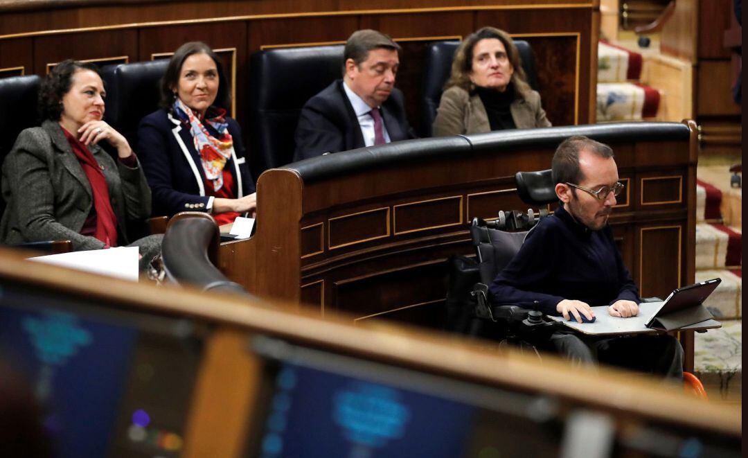 El diputado de Unidas Podemos, Pablo Echenique (d), sigue la intervención del candidato a presidente del Gobierno, Pedro Sánchez