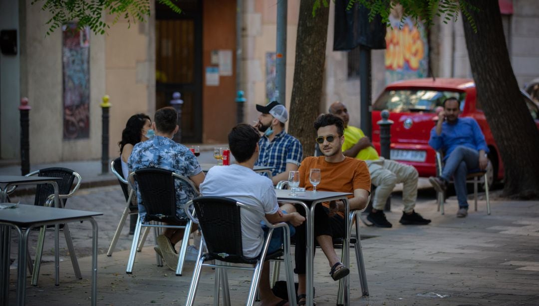 Varias personas disfrutan en la terraza de un bar.