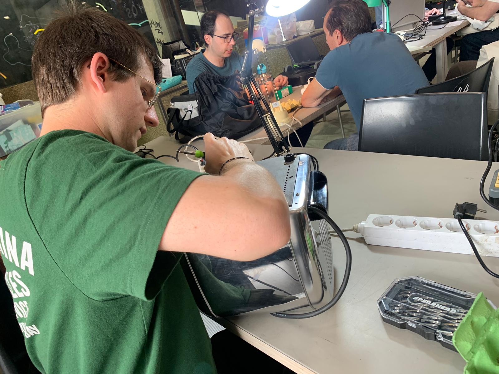 Un voluntario trabaja en arreglar un electrodoméstico estropeado.