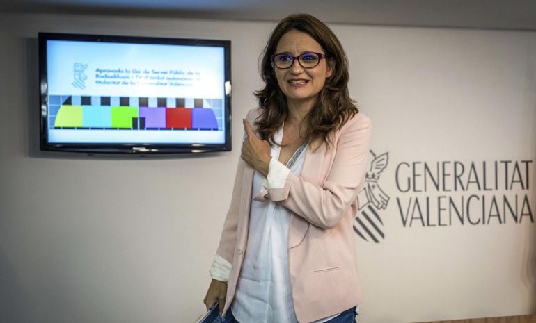 La vicepresidenta y portavoz del Consell,Mónica Oltra, señala el logotipo de la nueva RTVV, durante una rueda de prensa tras el pleno del Consell. 