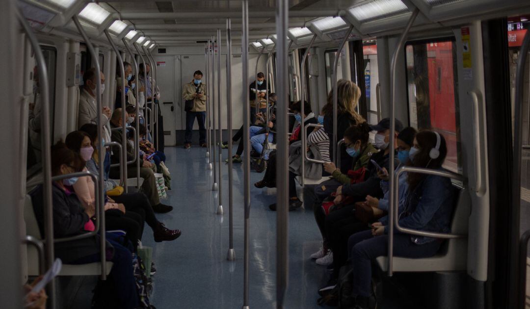 Varias personas viajan en el metro de Barcelona.