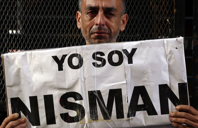 Marcelo Novillo, whose son Adrian was a victim of a violent crime, cries as he holds up a sign that reads &quot;I am Nisman&quot; outside the office of the prosecutor who is investigating the death of prosecutor Alberto Nisman in Buenos Aires January 22, 2015. Pros