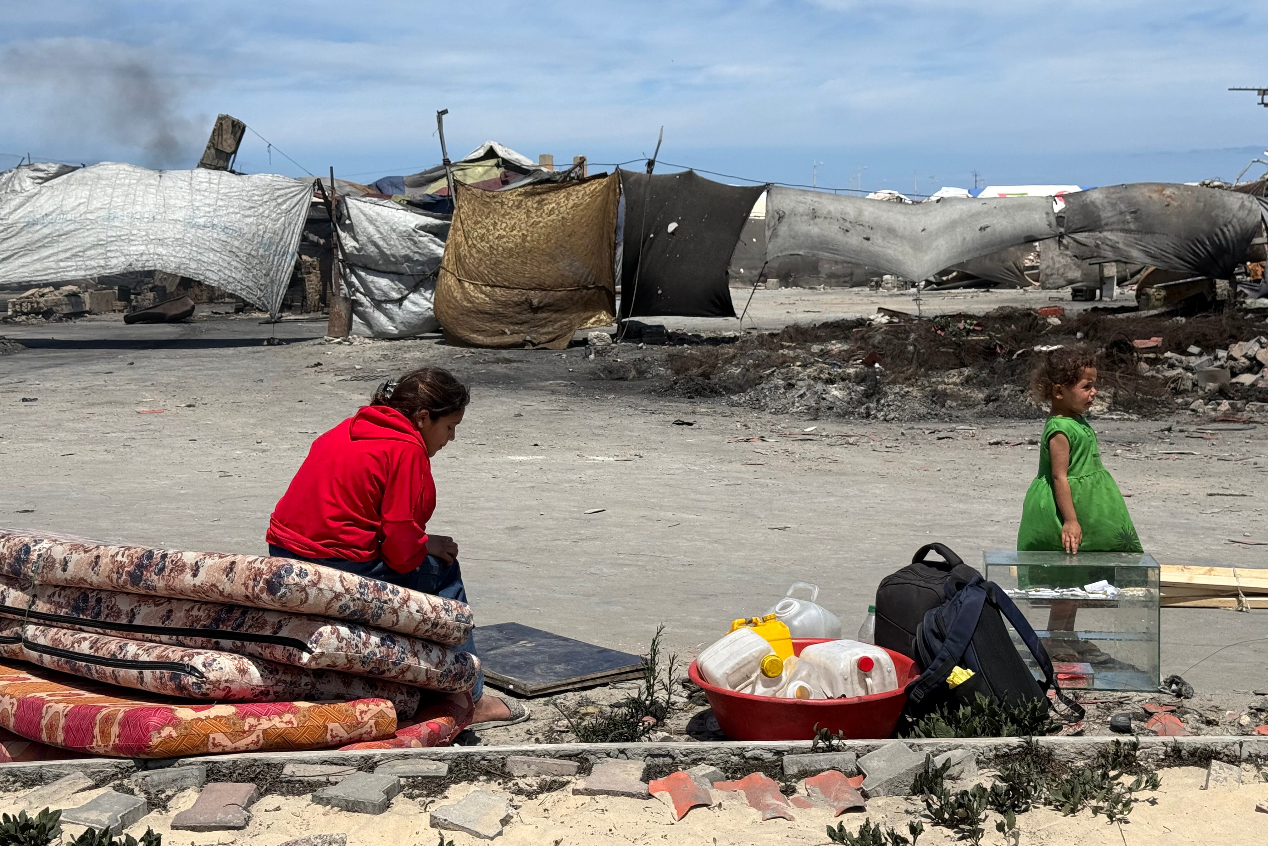 Una mujer y su hija aguardan en el puerto en la Ciudad de Gaza, donde miles de personas desplazadas por los ataques israelíes han encontrado refugio, este martes.